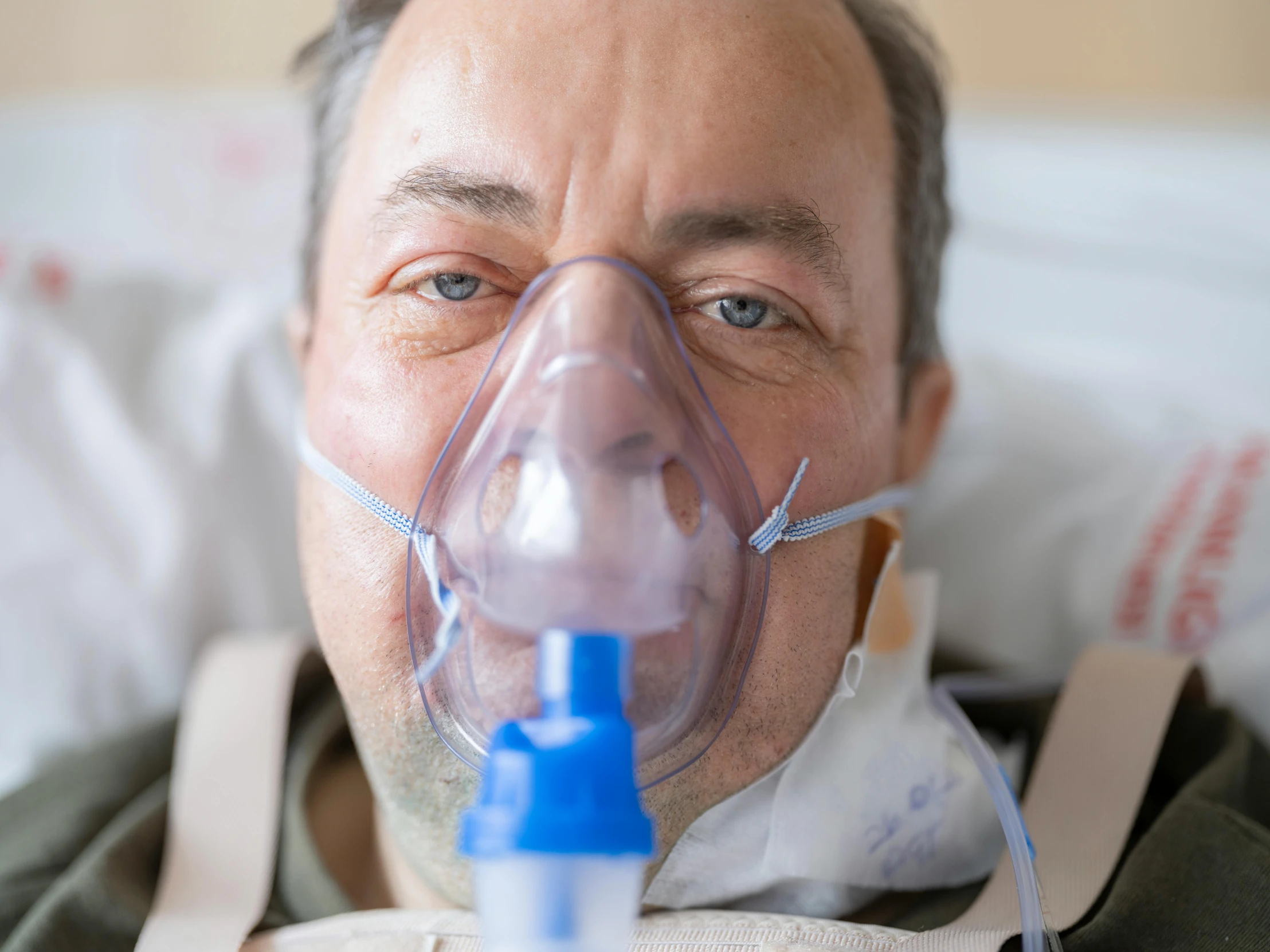 a man in a oxygen device in bed