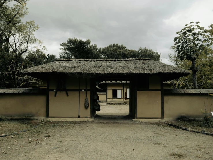 a stone gate with a thatch roof on top