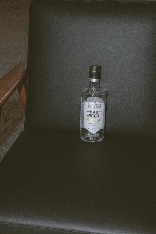 a small bottle is sitting on a chair