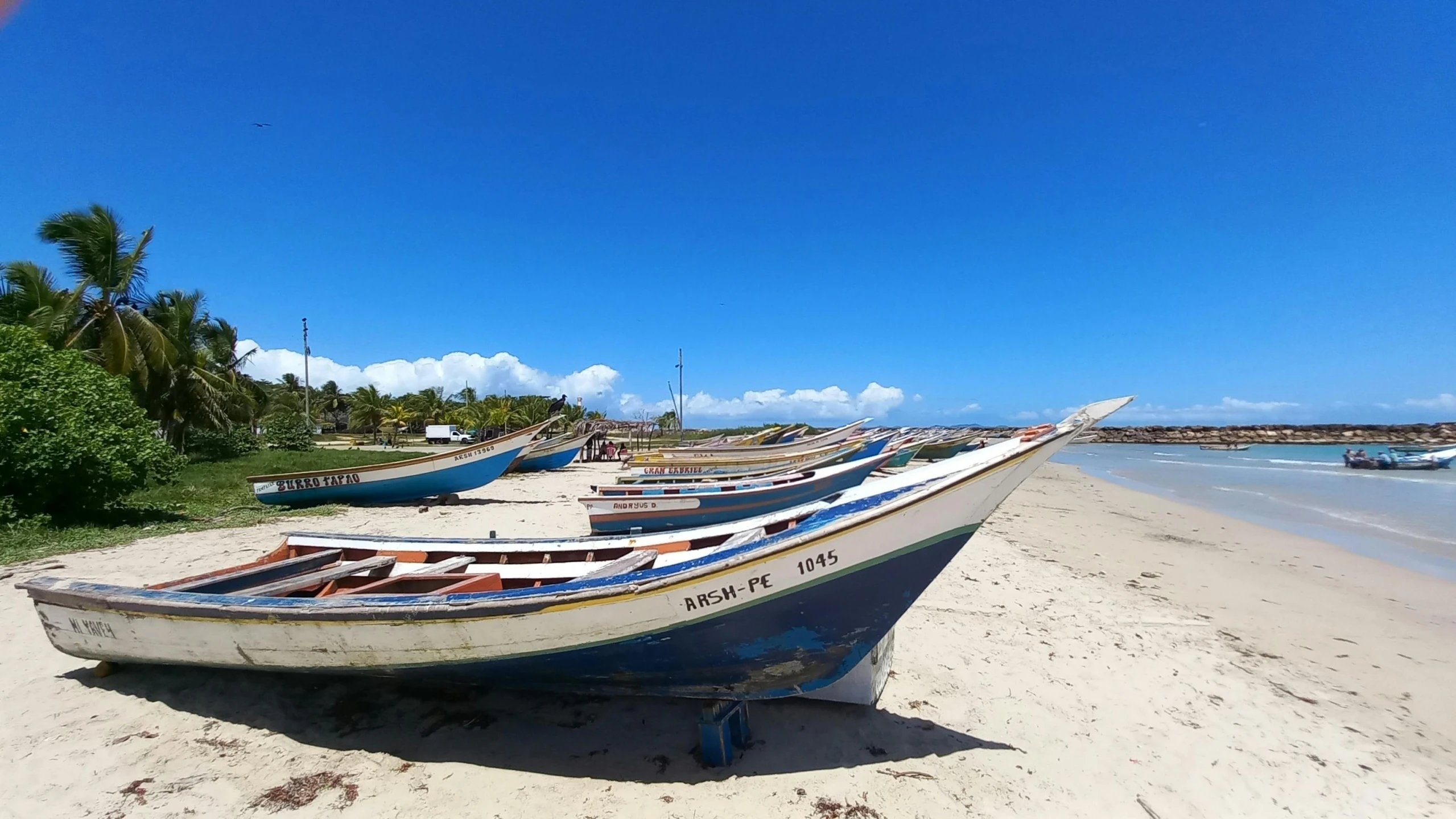 a number of small boats at the edge of water