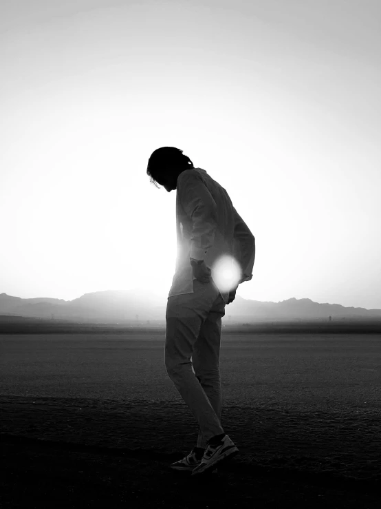 a man stands alone while holding his head