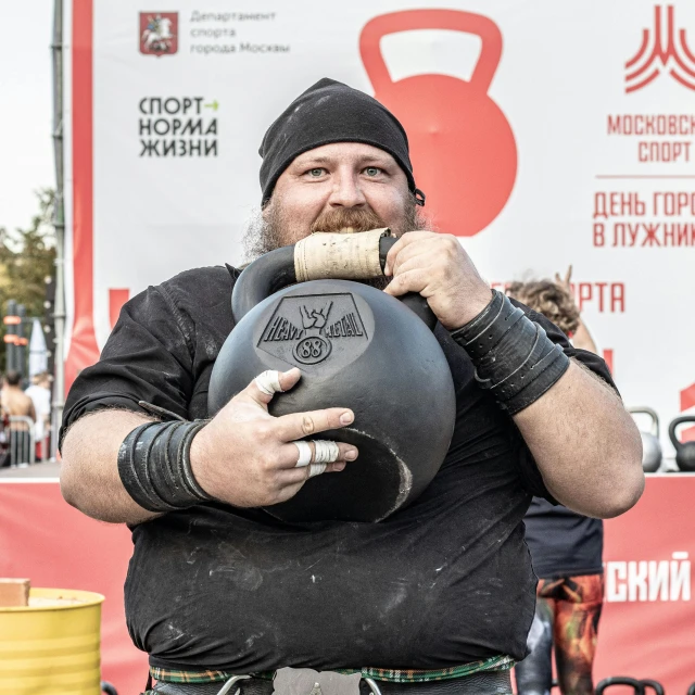 a large man with a big black ball in his hand