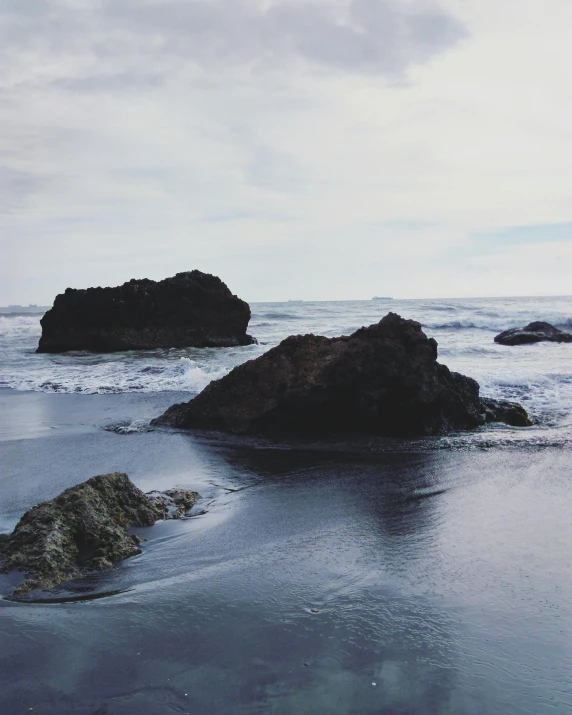 a black and white image of a rock formation in the ocean