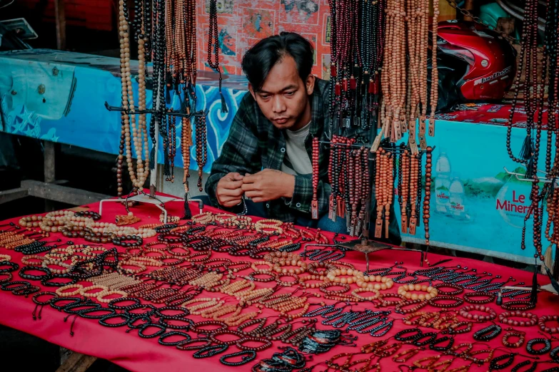 a man is at his store looking at a bead display