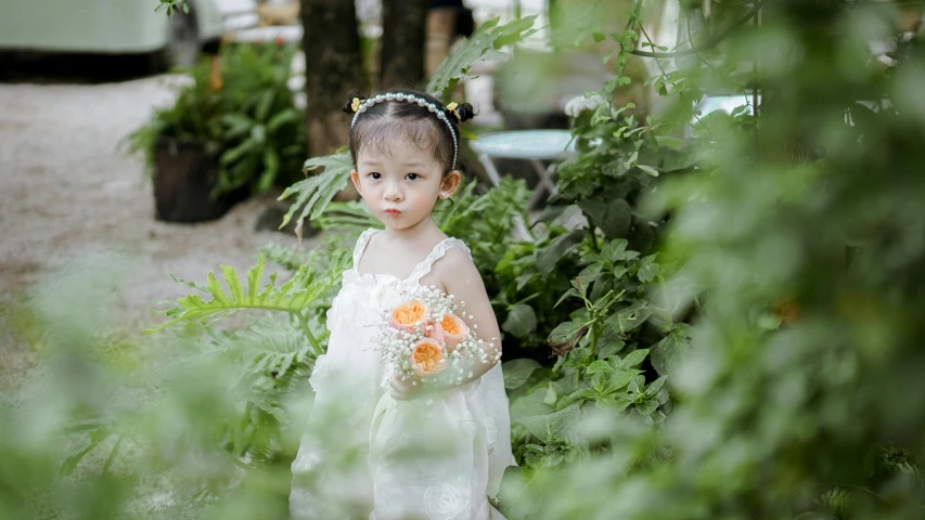 a  in a white dress and holding an orange bouquet