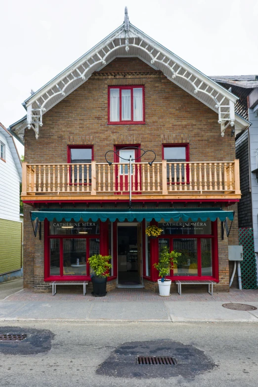 this red brick building has a large balcony on it's second floor