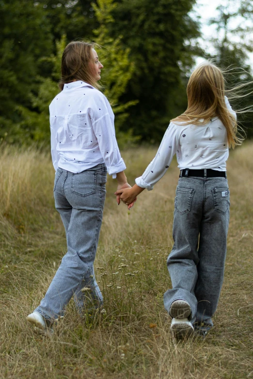 two young people hold hands in the field