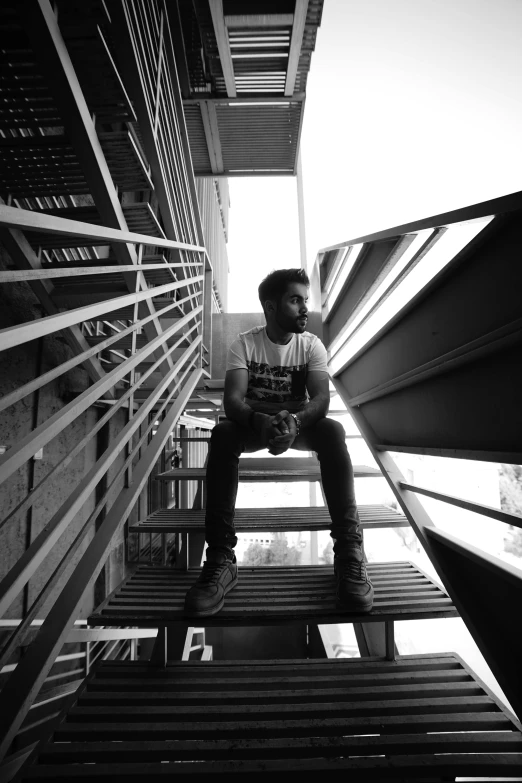 a man sits on some stairs holding his head in his hands