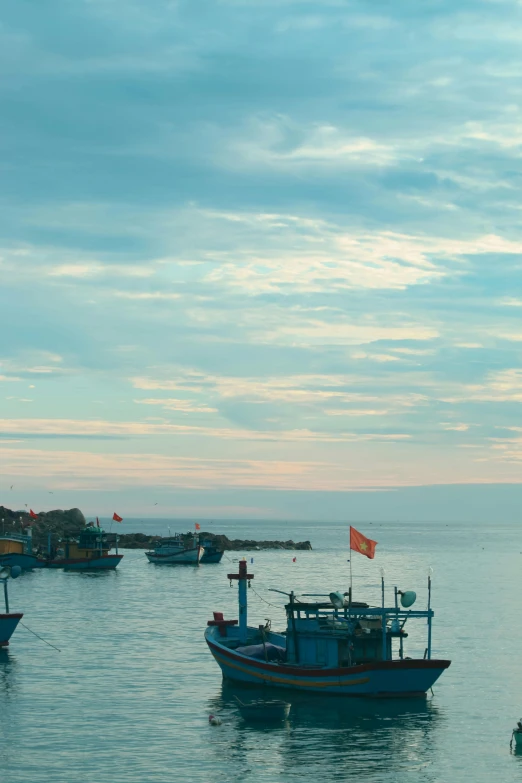 several small boats in the water with a flag on one of them