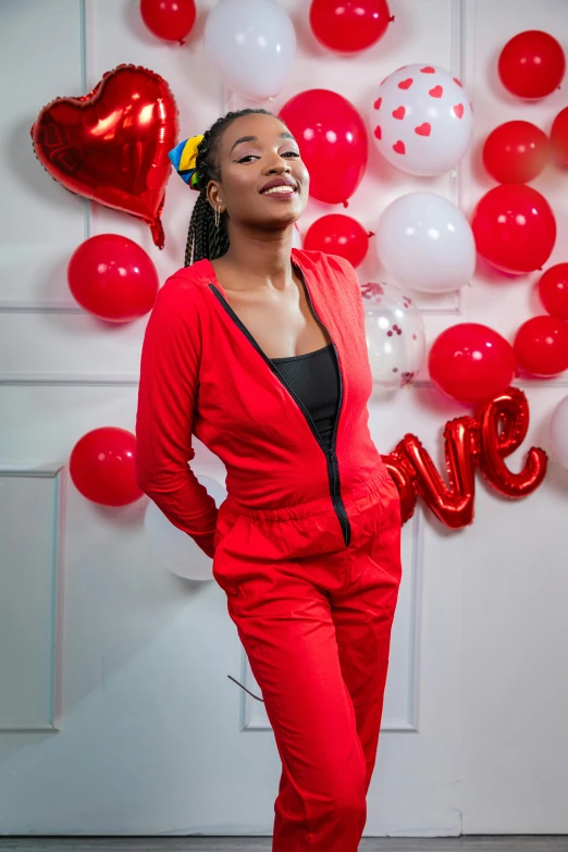 a woman in red outfit standing with balloons and a red balloon