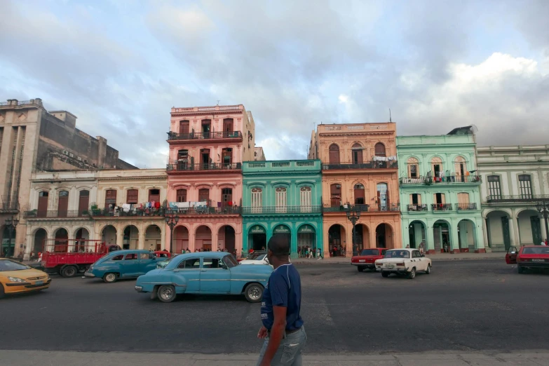 a man in front of colorful buildings on a street