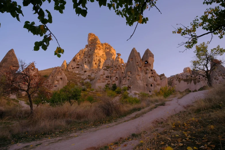 the ruins of old structures rise above a path in the mountains