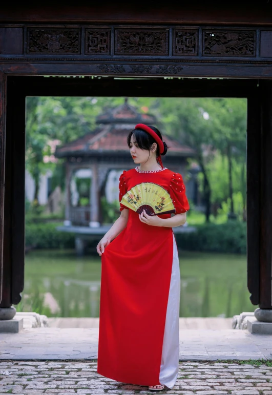 a woman in oriental clothing holding a fan