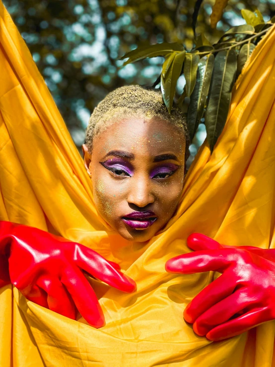 a woman with a gold make up and red gloves