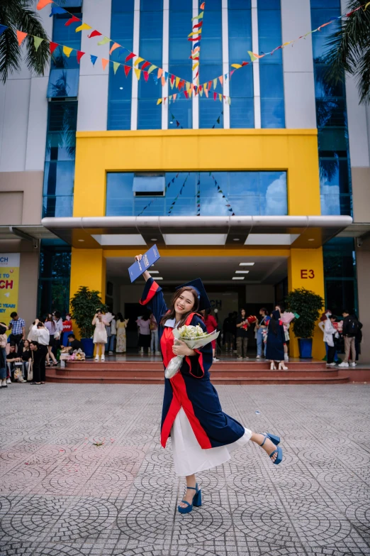 a woman in a red, white and blue dress with a bouquet stands outside a el