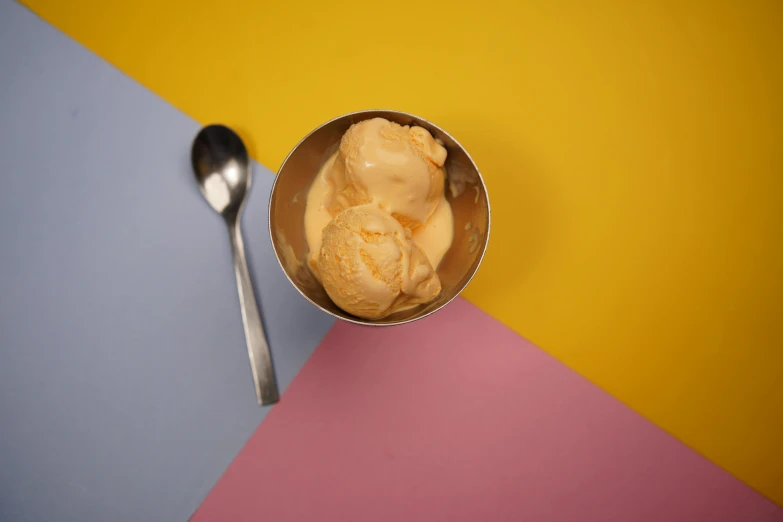 two scoops of ice cream are in a silver container with spoon