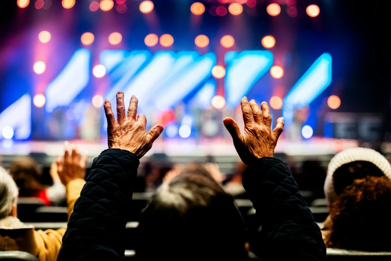 two people are sitting and raising their hands