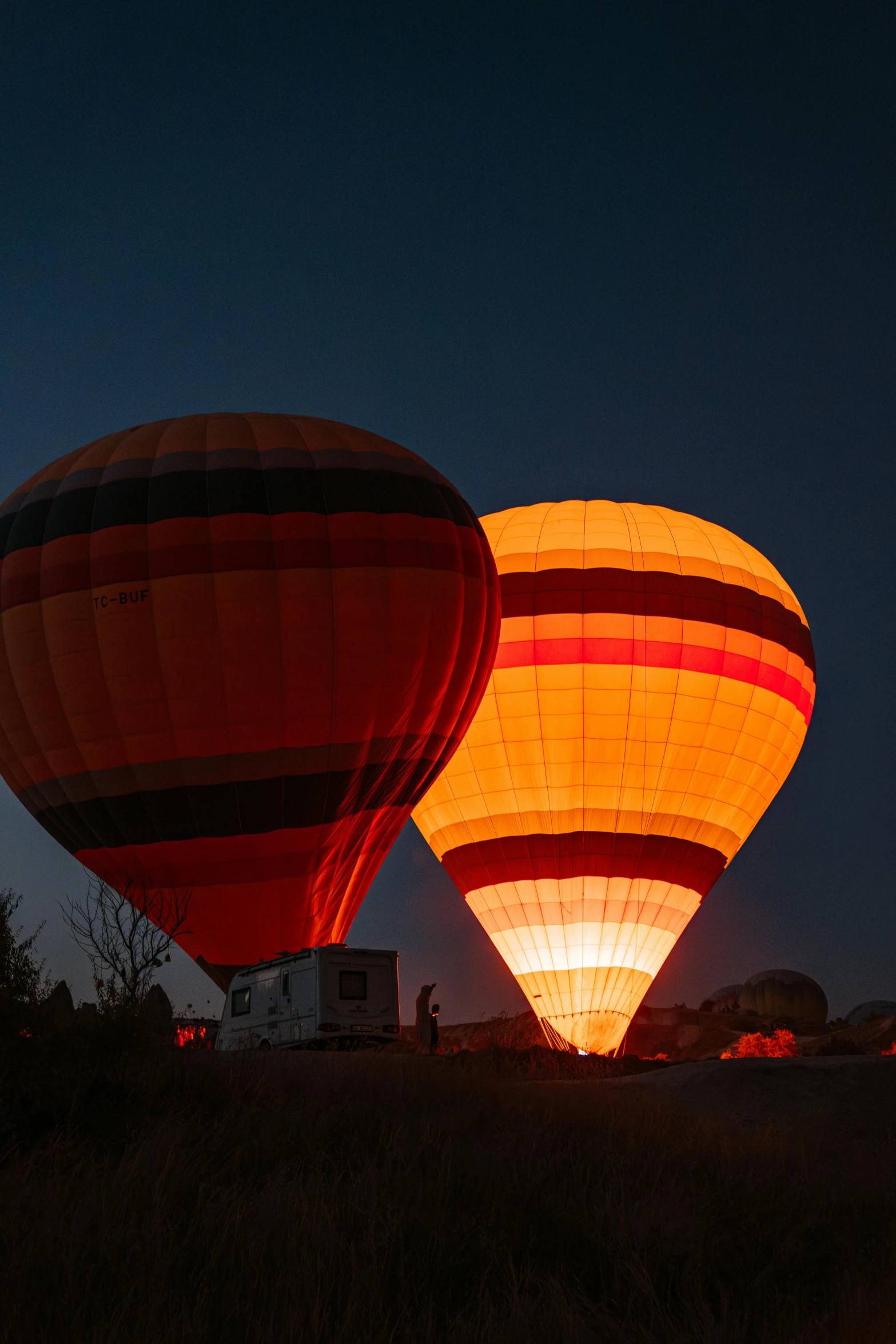 two balloons with lights lit up in the night sky