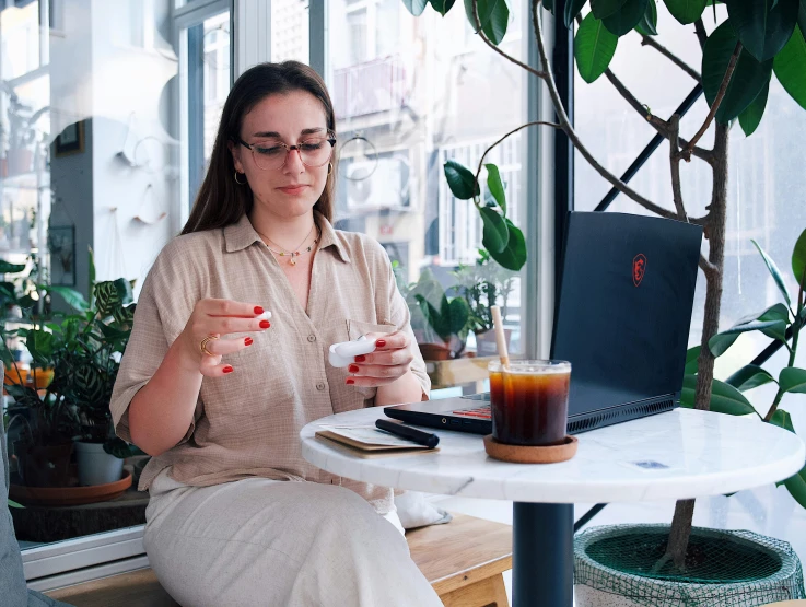 a woman sitting at a table in front of a laptop