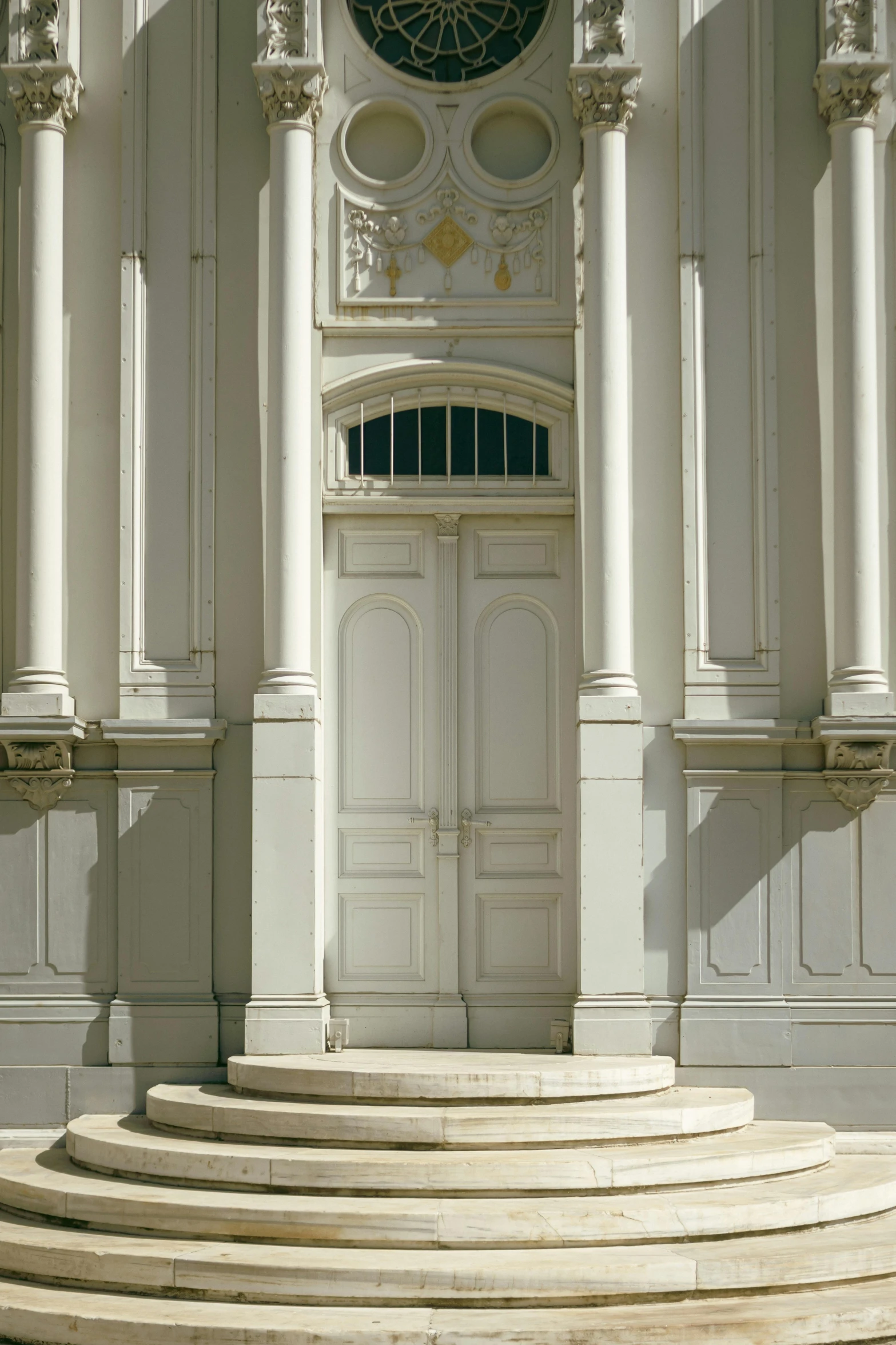 a building with two clocks built on it's face and pillars