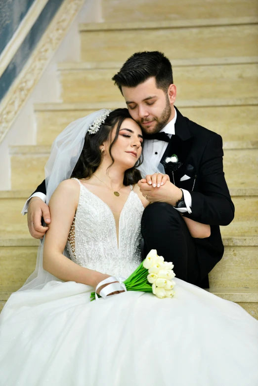 a bride and groom posing for a po while sitting on steps