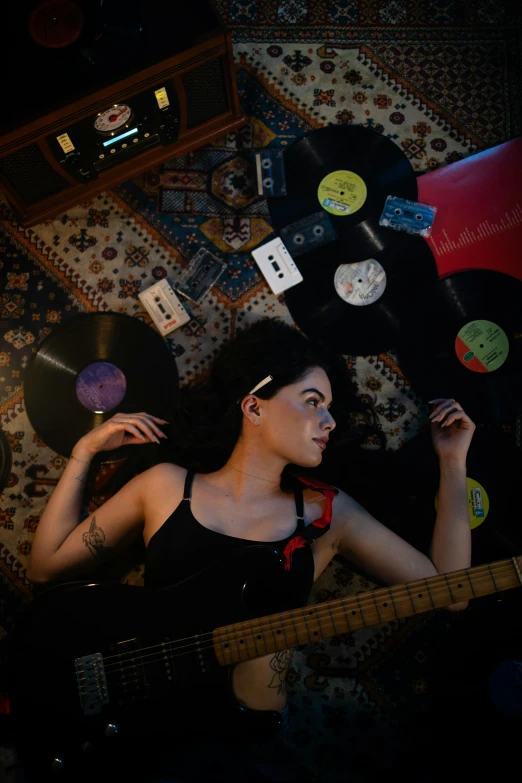 a young woman in a black shirt and red tie playing an electric guitar