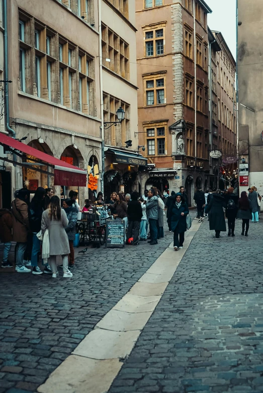 a cobblestone street with lots of people walking in the distance