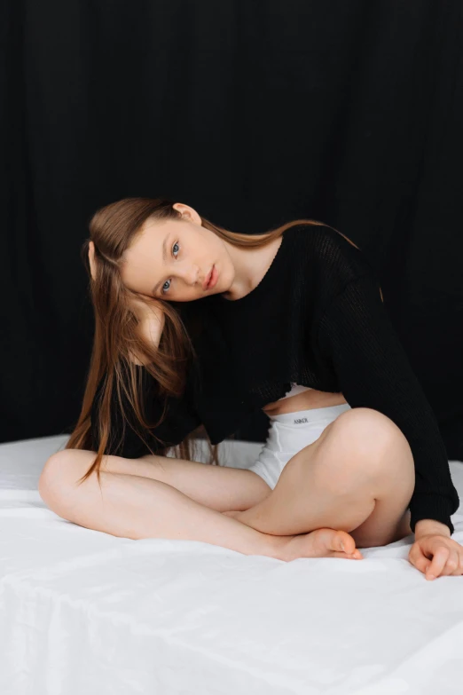 a beautiful young lady sitting on top of a bed