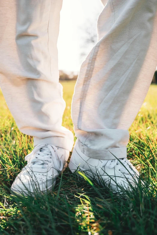 a close up of someone wearing white tennis shoes