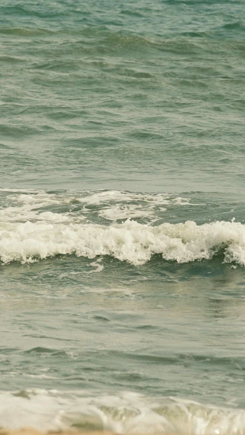 two surfers walking towards the surf at a beach