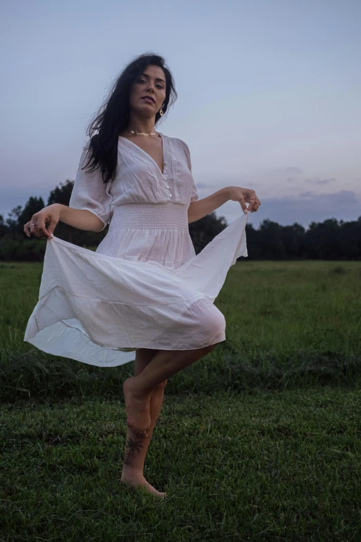 a woman standing on top of a grass covered field