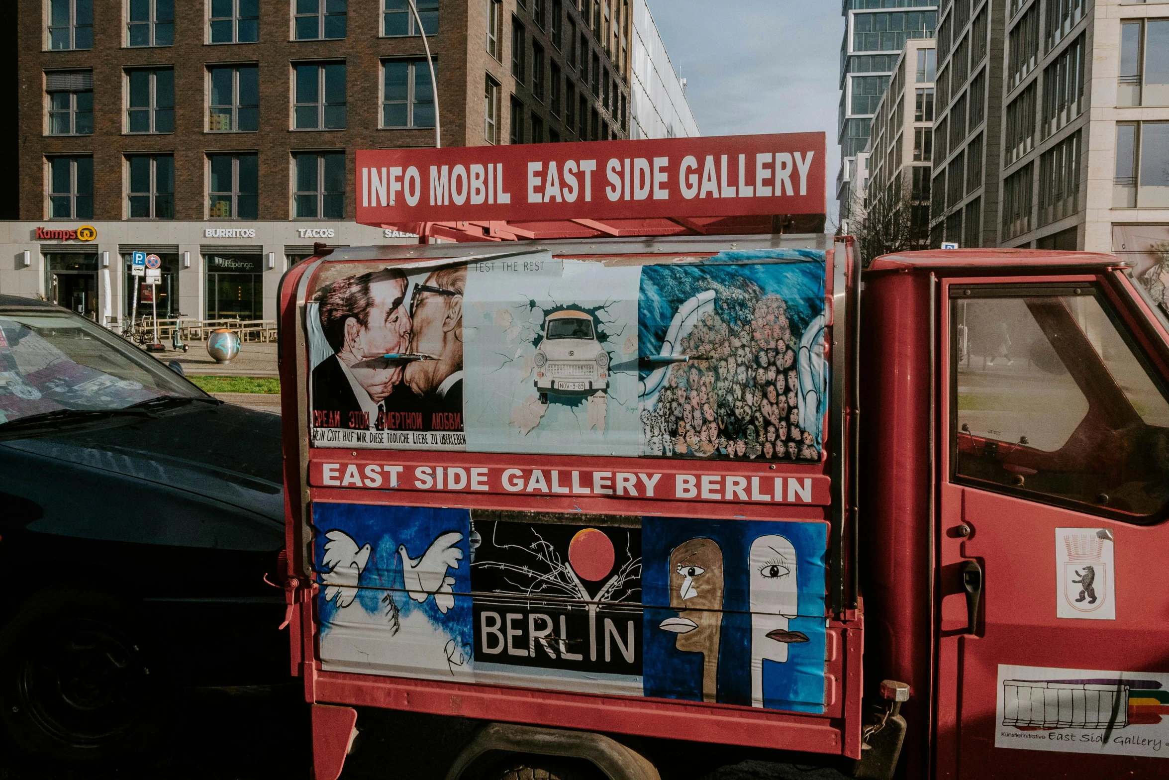 a red truck that has pictures of people painted on it