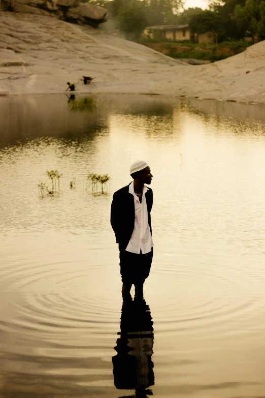 a man standing in the water talking on a cell phone