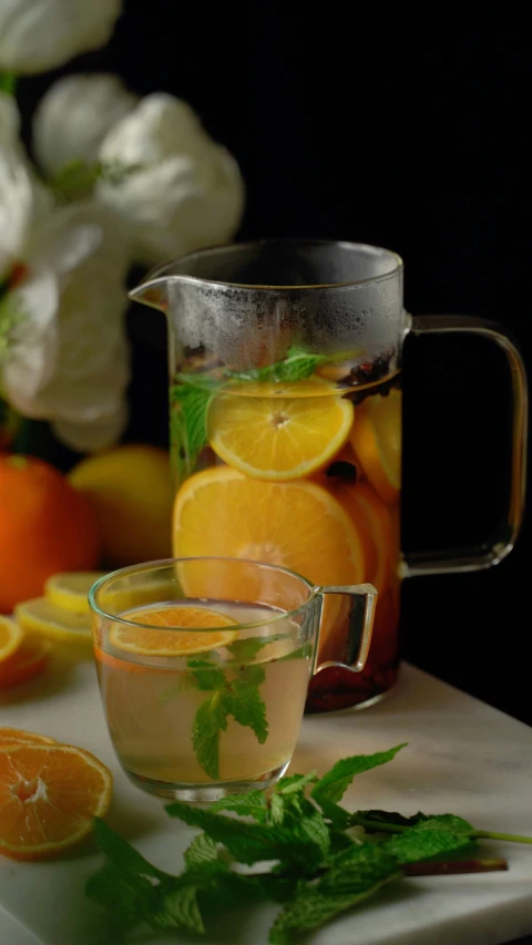 there is oranges, lemon and green leaves in the tea