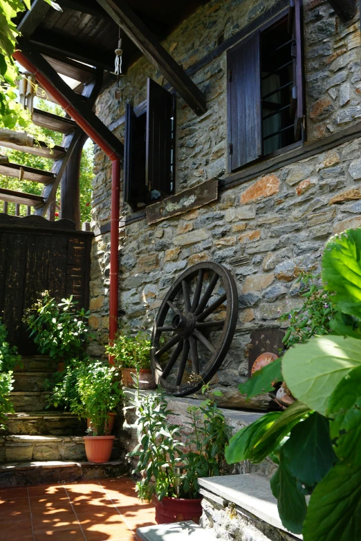 an outside patio with flowers, plants and stone building