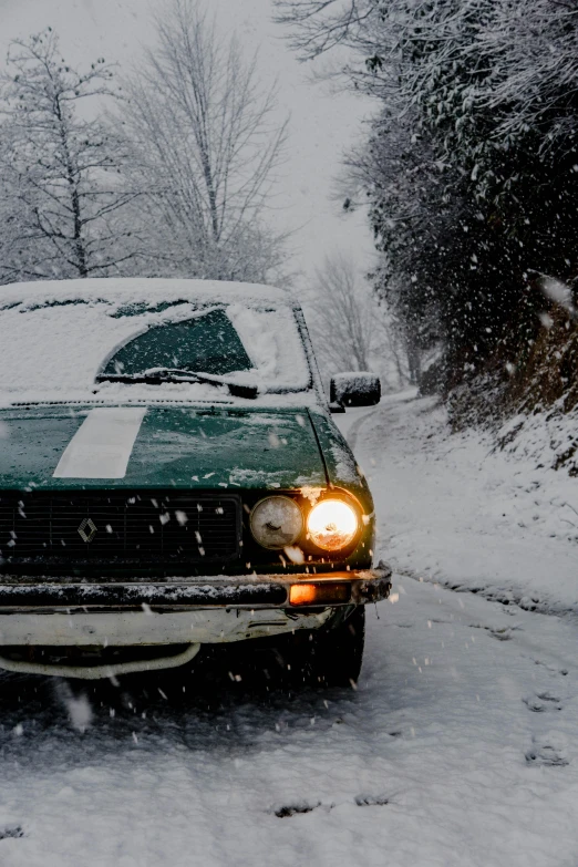 the green pickup truck is driving on a snowy road