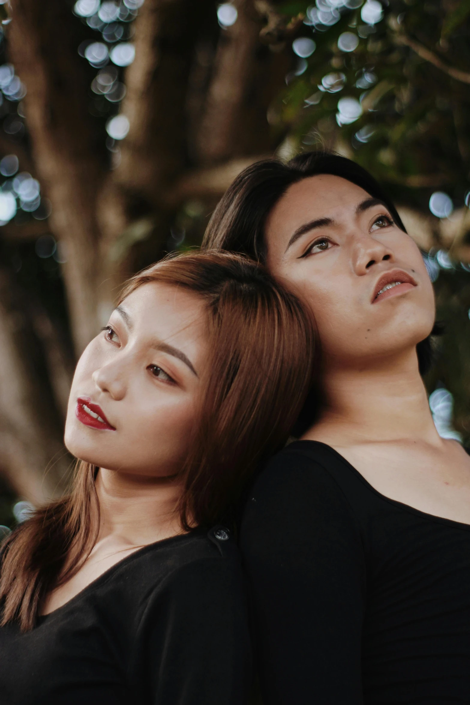 two young women are looking up into the sky