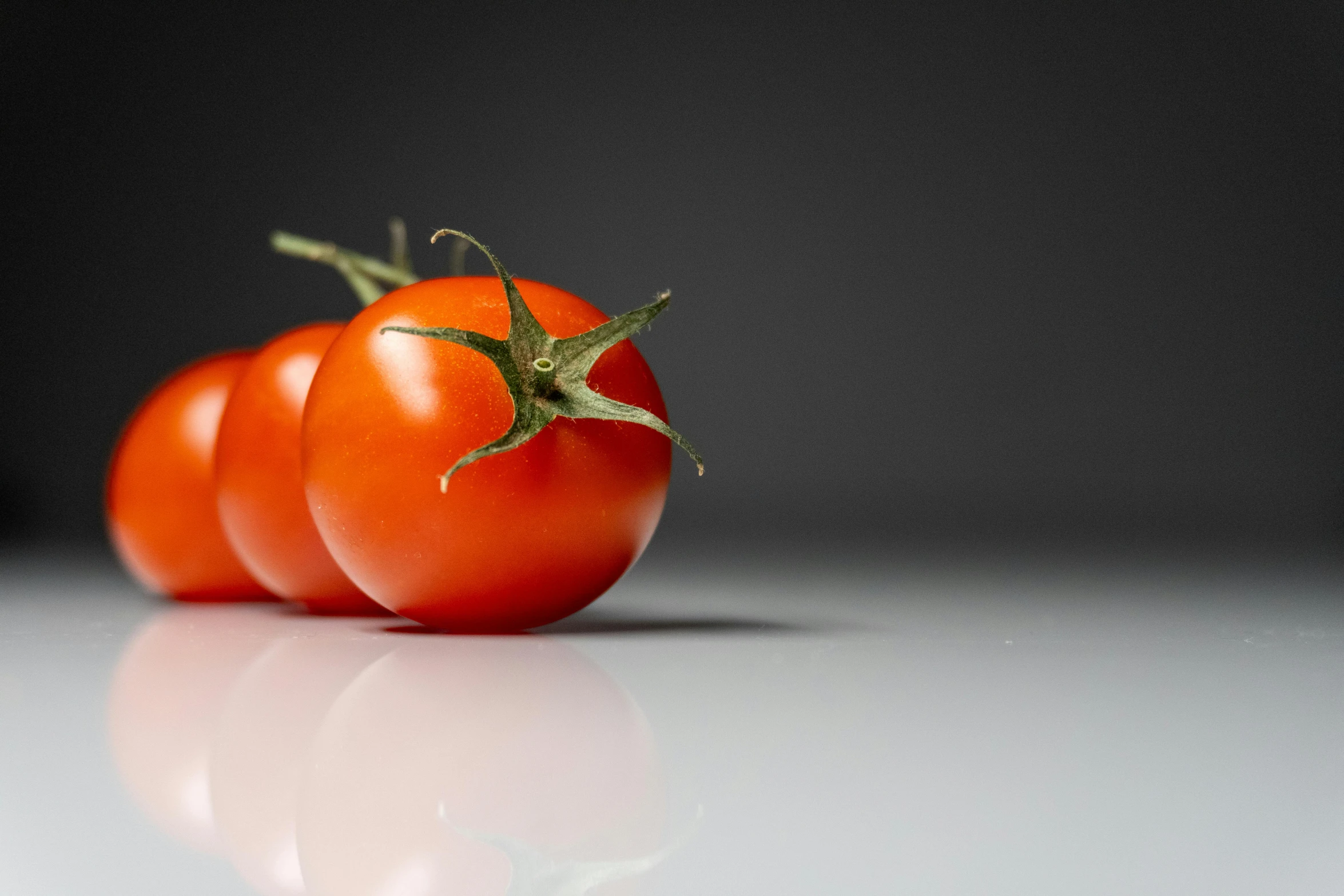 a group of three tomatoes sitting next to each other