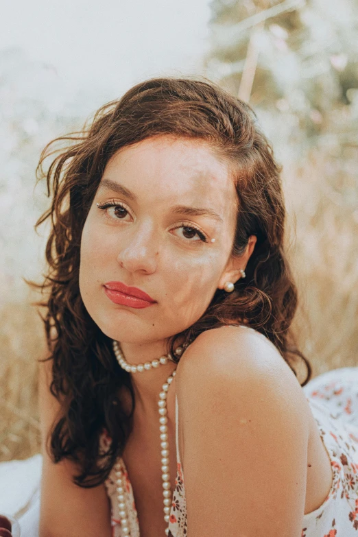 the woman is posing for the camera while wearing a pearl necklace