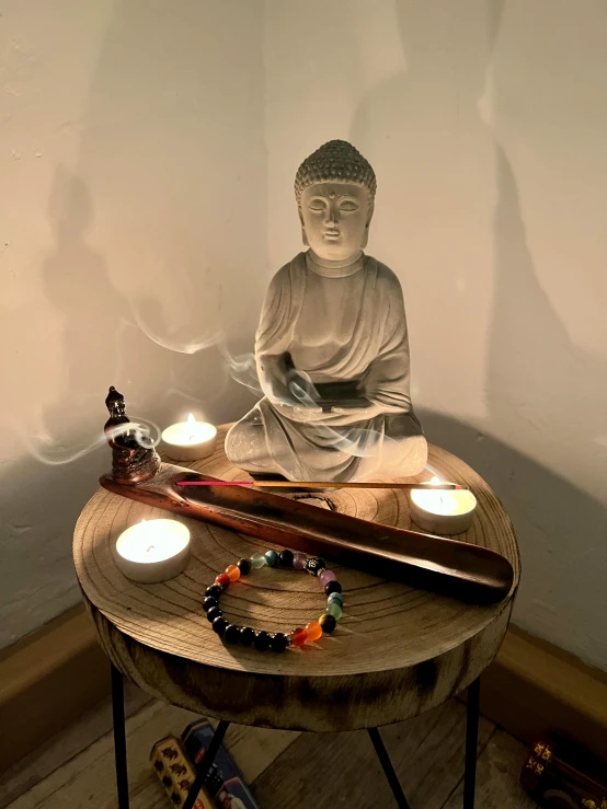 a wooden table topped with an illuminated buddha statue