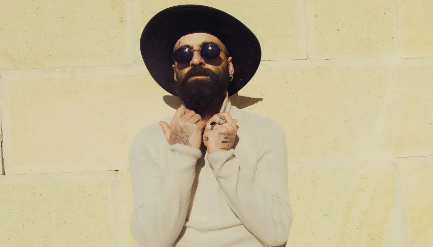 a man in sunglasses and hat posing for a po