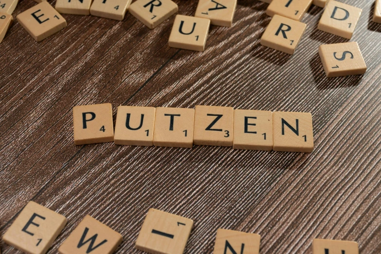 scrabbled words laid out on a wooden surface to spell out the word, pultzen