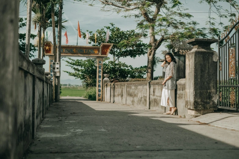 a woman is standing near the fence with her phone