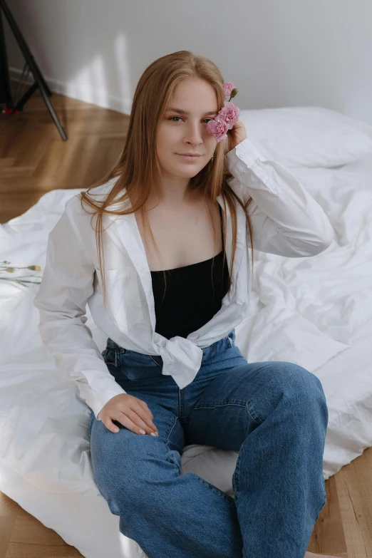 a woman with a flower in her hair is sitting on the floor