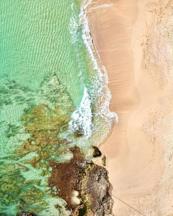 top down view of people flying a kite on the beach