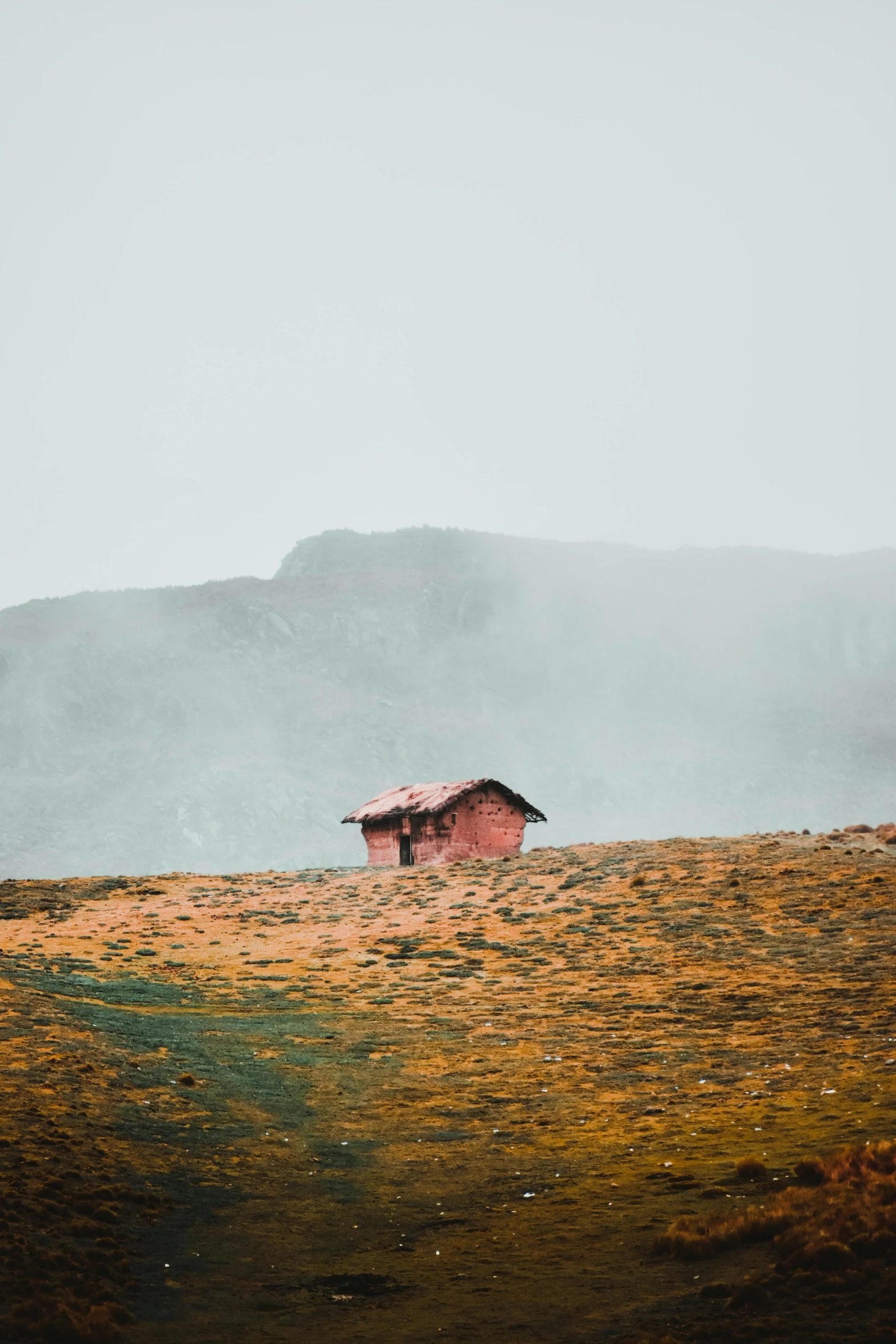 a small red building sits in the grass