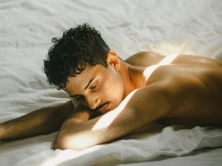 a young man sleeps while lying down on a blanket