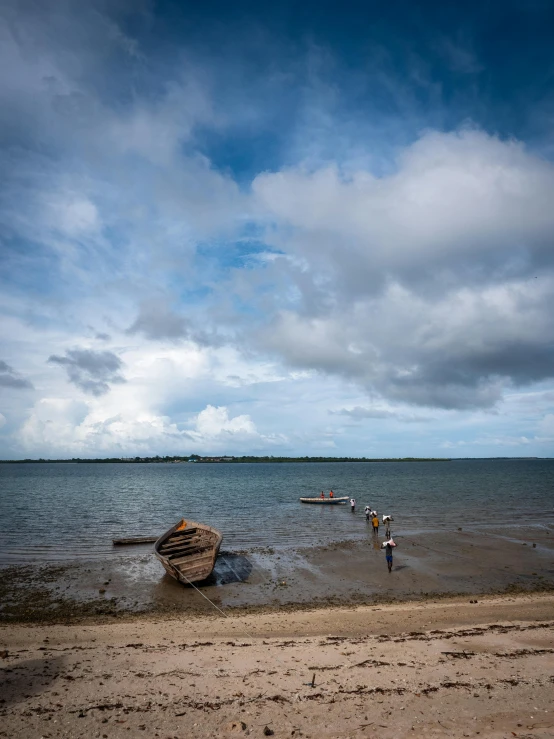 a group of people on the beach near the water