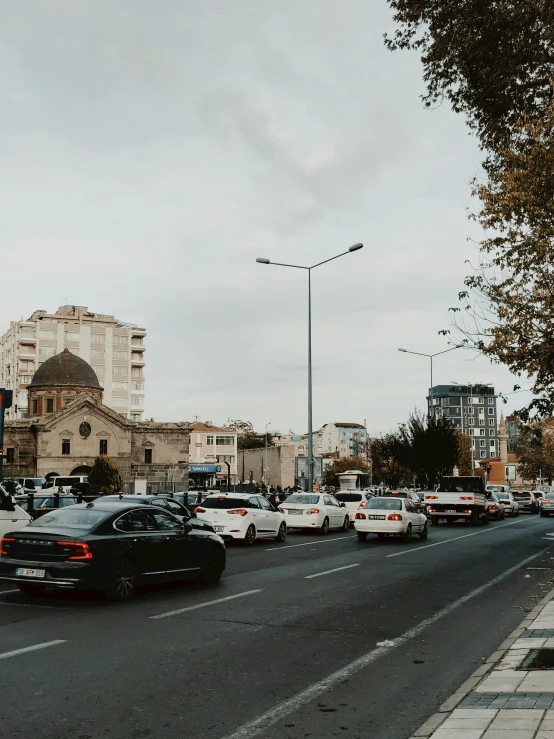 cars are traveling down a street lined with buildings