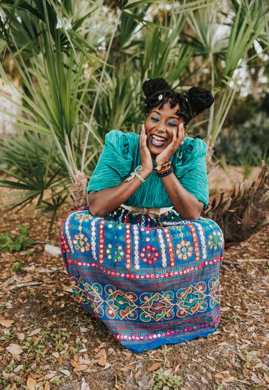 a black woman sitting on the ground and smiling